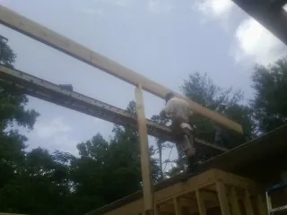 Carpenter setting a ridge beam over a new addition frame — Ice Dam Removal by Roofing Brothers in Nezperce