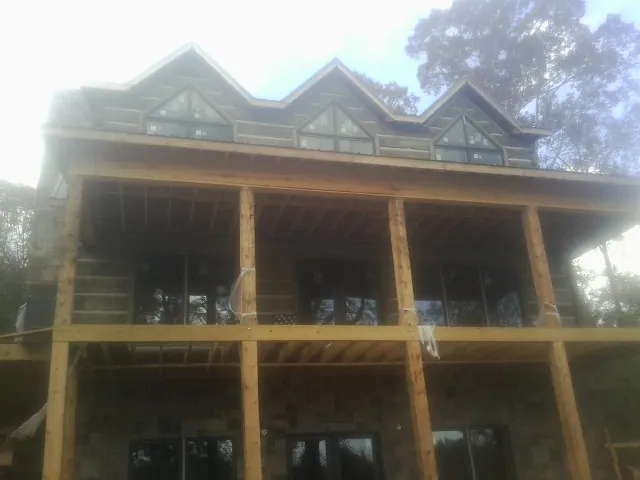 Dormers and porch framing on a large log home under construction — Roof Coating work by our crew in Nezperce
