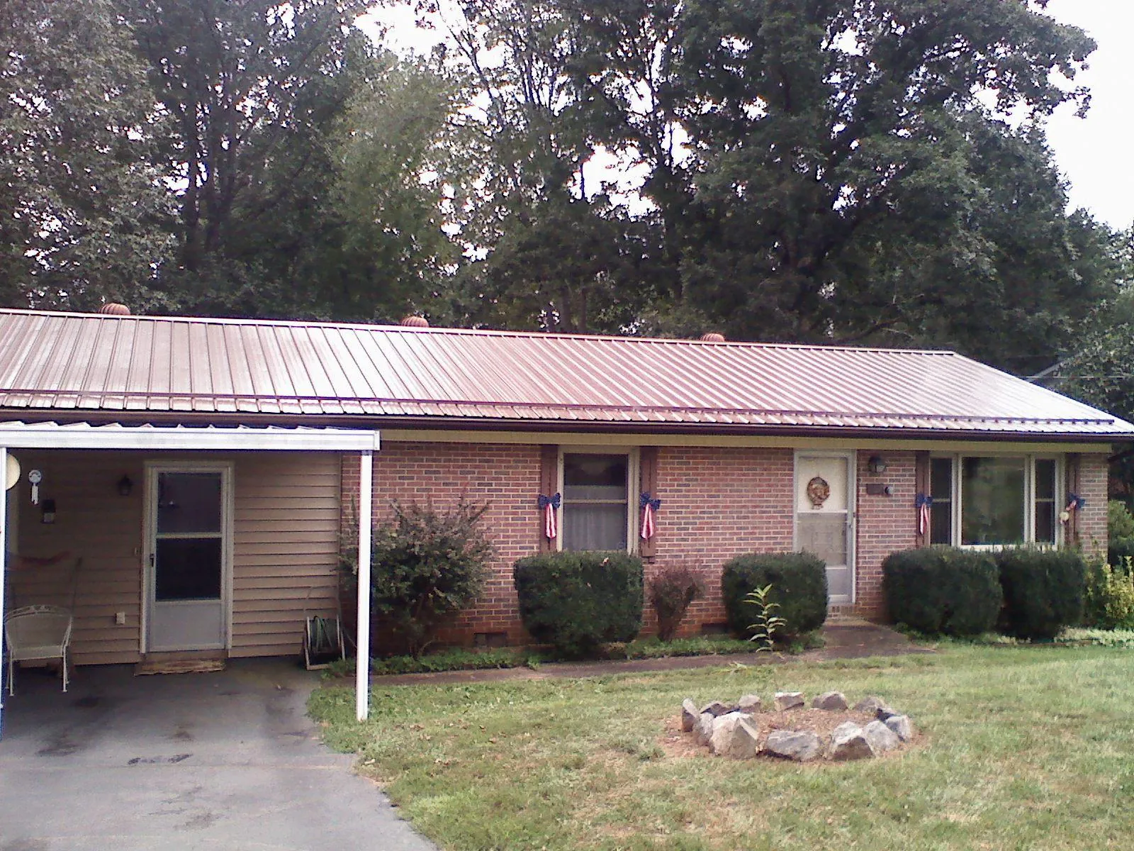 Bronze metal roof and carport on a brick ranch home — Roof Repair work by our crew in Nezperce
